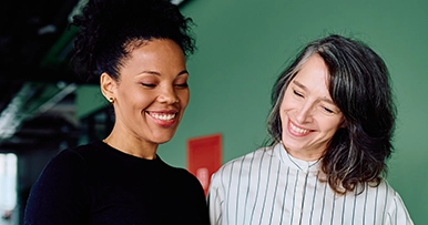 Two women smiling and reviewing documents